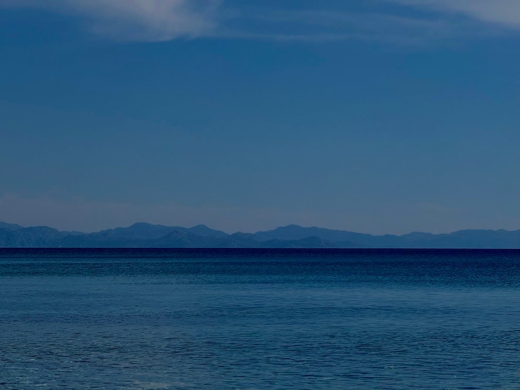 A view of the sea with mountains ahead 